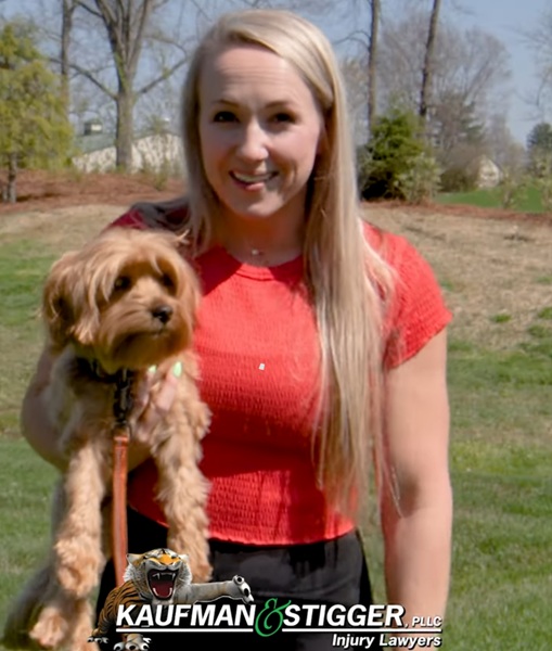 Katrina Kaufman, wife of Attorney Jimmy Kaufman, holds dog "Tiger" in yard on sunny day in Louisville.